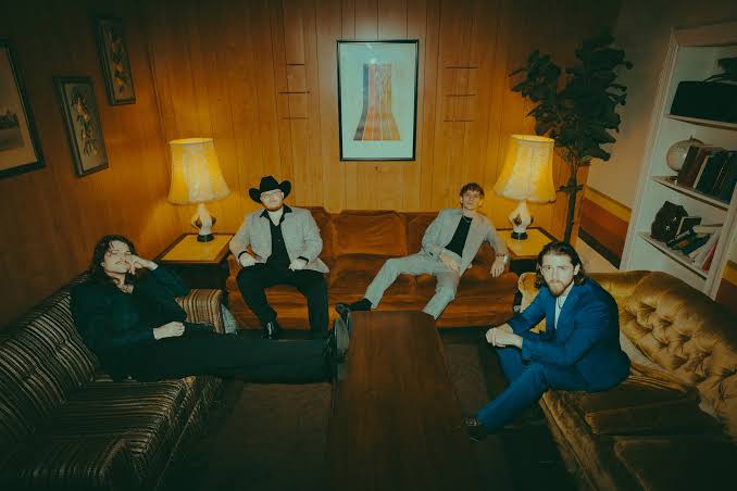 Fox N’ Vead seated together in a wood-paneled room