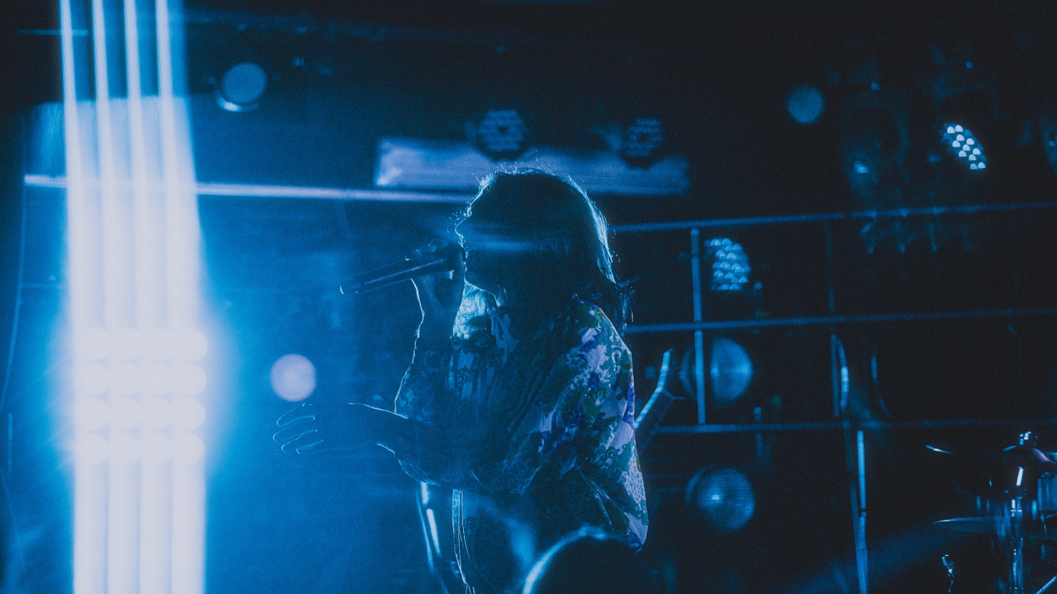Vespera vocalist performing in blue light